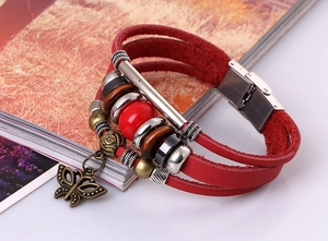 Detail of red multilayer leather beaded bracelet with bronze butterfly charm and steel clasp