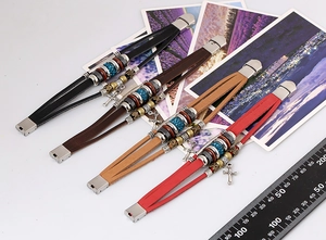 Detail view of multi-layer vintage leather bracelets with metal cross charms and beads