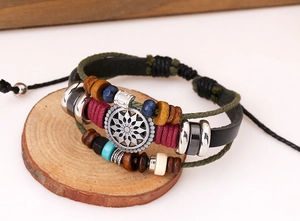 Macro detail of multi-layer leather bracelet with wooden beads and silver floral charm