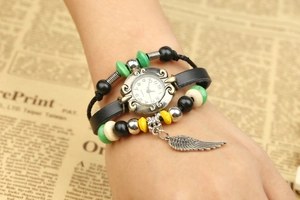 Detail of vintage leather wrap watch with colorful beads and silver wing charm