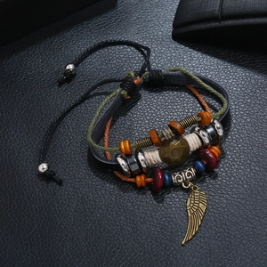 Detailed close-up of multi-layer leather bracelet with vintage gold feather pendant