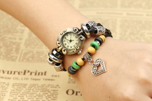 Détail de la montre bracelet en cuir vintage avec perles et breloque cœur en bronze poli