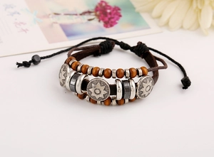 Detail of vintage multilayer braided leather bracelet with wooden beads and engraved star charms