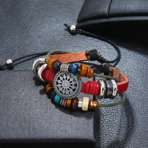 Macro shot of boho leather bracelet with colorful beads and vintage sun pendant detail