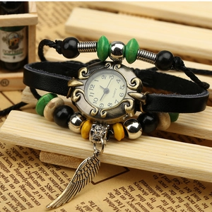 Retro quartz leather wrap watch with colorful beads and metal feather pendant on wood