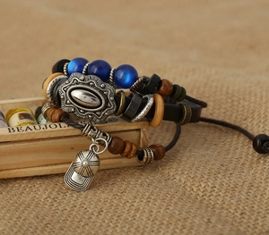 Detail of leather wrap bracelet with baseball cap pendant and wooden beads on burlap