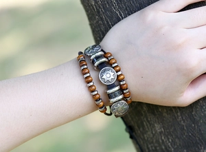 Detail of bohemian multilayer beaded leather bracelet with sunburst charm on wrist