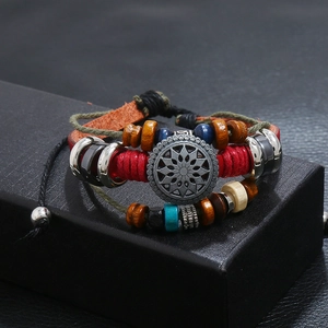 Detail of bohemian multilayer leather bracelet with colorful wooden beads and sunburst charm