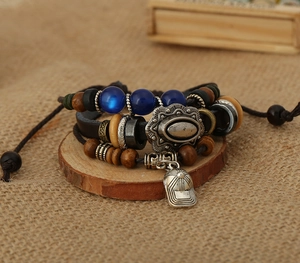 Detail of multi-layer beaded leather bracelet with a vintage silver baseball cap pendant