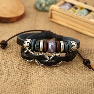 Close-up of multilayer leather bracelet with silver heart charm and purple bead on burlap