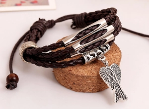 Detail of vintage multilayer braided leather bracelet with silver wing charm and beads