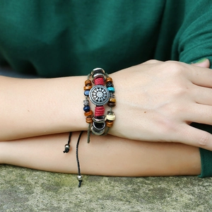 Macro detail of bohemian leather wrap bracelet with colorful beads and ethnic metal charm