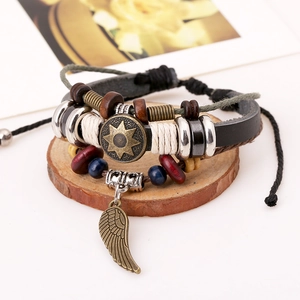 Retro multi-layer leather bracelet with bronze sun charm and feather pendant on wood
