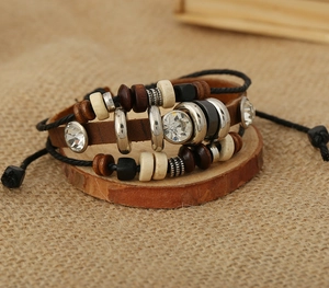 Détail du bracelet bohème en cuir avec perles en bois et trois strass blancs