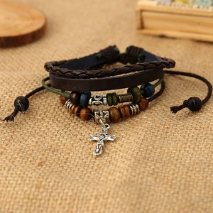 Detail of multi-layer leather bracelet with wooden beads and silver INRI cross charm