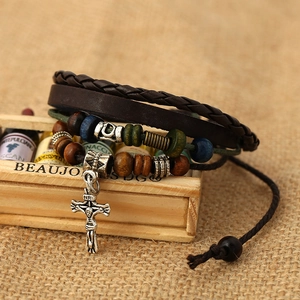 Multilayer leather bracelet with wooden beads and vintage silver cross pendant on burlap
