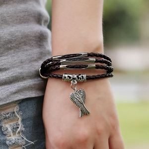 Multilayer dark brown braided leather bracelet with vintage silver wing pendant on wrist