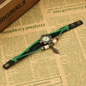 Detail of vintage bohemian woven leather watch with bronze leaf charm and wooden beads