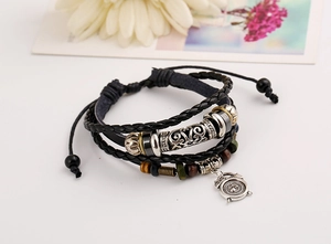 Detail of multi-layer leather bracelet with alarm clock pendant and vintage beads