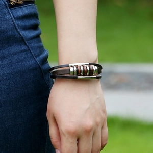 Retro multilayer woven leather bracelet with vintage beads on a male wrist in daylight