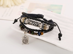 Macro shot of multi-layer leather bracelet featuring alarm clock pendant and wooden beads