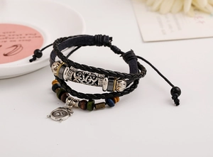 Macro shot of multi-layer beaded leather bracelet with alarm clock pendant and wooden beads