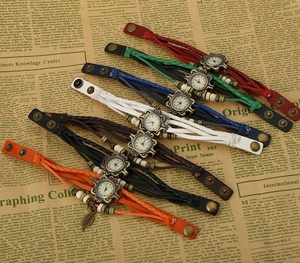 Close-up of vintage braided leather watches with metal leaf pendants in seven colors