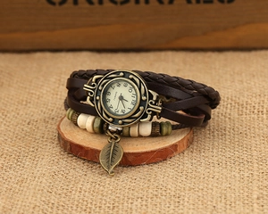 Close-up of vintage multi-layer leather bracelet watch with bronze leaf and wood beads