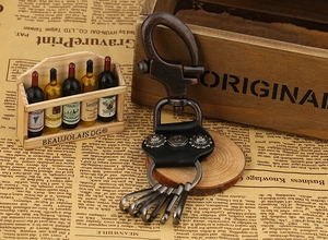 Vintage punk style leather keychain with antique bronze metal hooks on wooden background