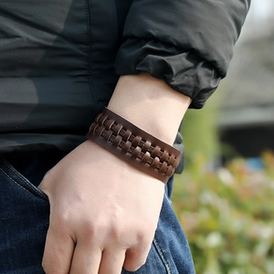 Gros plan d'un bracelet vintage en cuir marron tressé porté par un homme en extérieur