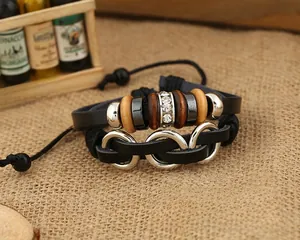 Détail macro d'un bracelet multicouche en cuir noir avec perles en bois sur toile de jute