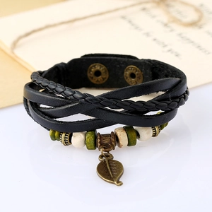 Detail of multi-layer leather bracelet with bronze leaf charm and wooden beads on white surface