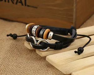 Détail du bracelet multicouche en cuir avec symbole infini et perles de bois sur bois