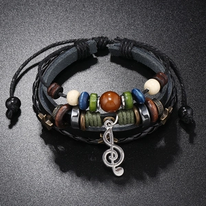 Detail of multi-layer beaded leather bracelet featuring a silver treble clef music charm