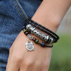 Detail of multi-layer leather bracelet with wooden beads and alarm clock pendant