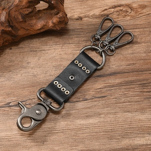 Detail eines Vintage-Punk-Leder-Schlüsselanhängers mit Metallnieten und Karabinerhaken