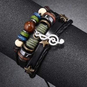 Detail of multi-layer beaded leather bracelet featuring a silver treble clef music pendant