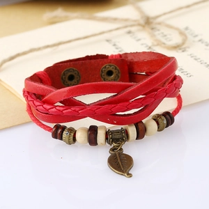 Detail of red multilayer braided leather bracelet with vintage leaf charm and wooden beads