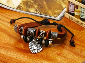 Détail d'un bracelet multicouche en cuir bohème avec perles de bois et breloque cœur