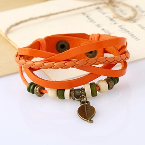 Detail of orange multilayer leather bracelet with bronze leaf pendant and beads
