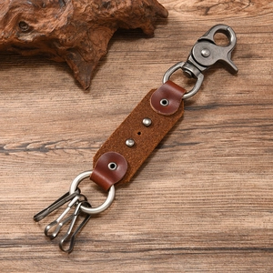Detail of punk leather skull keychain with spring hook on a natural wood background