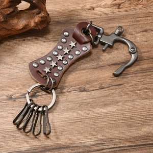 Detail of vintage brown leather keychain with metal studs, star motifs and zinc alloy hooks