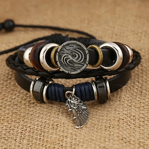 Bracciale multistrato in pelle da uomo con ciondolo a piuma su sfondo di tela di sacco