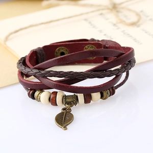 Detail of vintage braided leather bracelet with leaf pendant and adjustable snap buttons