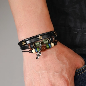 Detail of layered leather bracelet with musical note charm and gold stars on wrist
