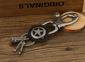 Macro shot of vintage alloy star keychain with leather strap on rustic wood background