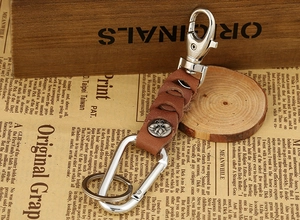 Close-up of brown braided leather keychain with vintage metal rivet and silver snap hook