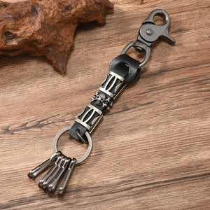 Detail of punk skull keychain with leather strap and silver metal hooks on wood background