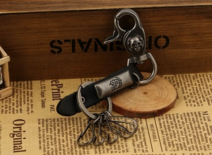 Vintage style leather keychain featuring a metallic skull hook and engraved circular charm