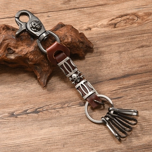 Macro detail of punk skull keychain with vintage silver buckle and brown leather strap